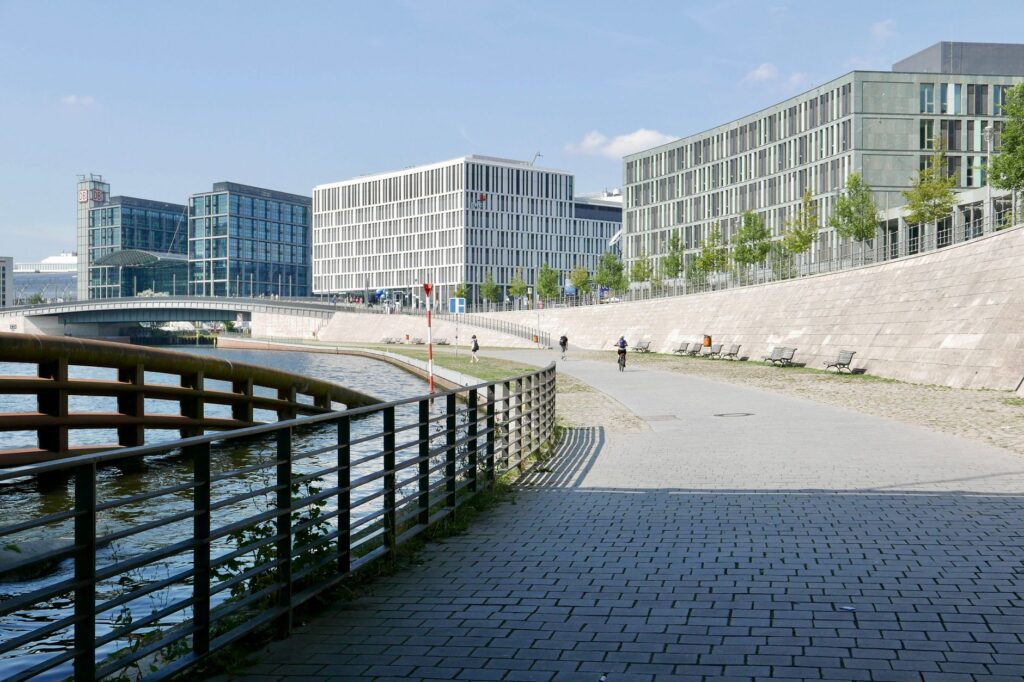 Modern architecture along the river in Berlin, Germany with a scenic promenade.