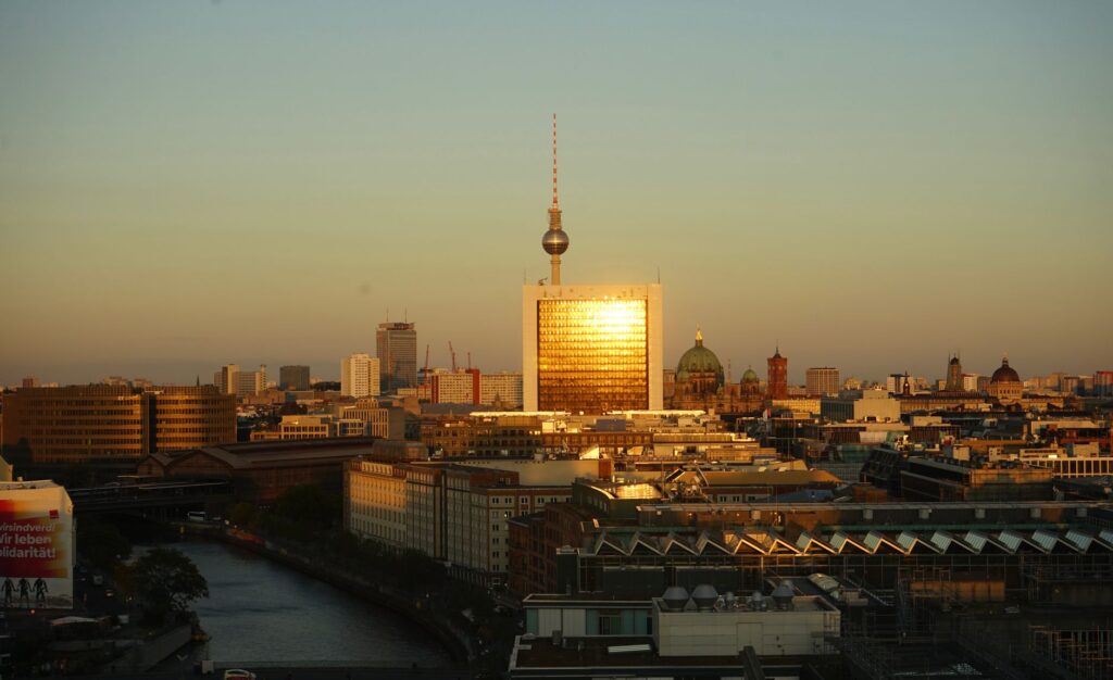 Scenic view of Berlin skyline featuring iconic TV Tower glowing in sunset light.