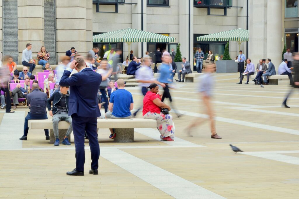 People in motion at Paternoster Square, capturing vibrant city life near St. Paul's Cathedral, London.