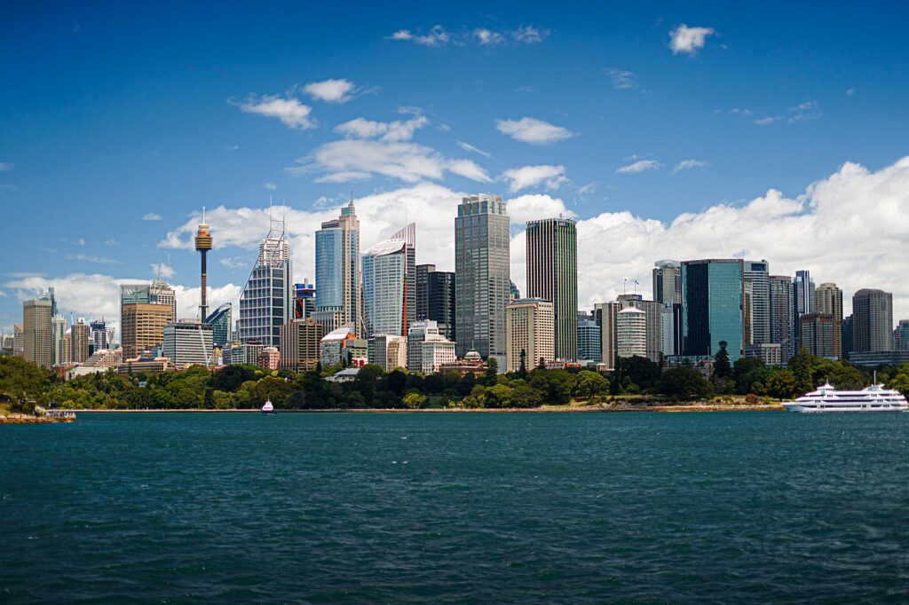 View of Sydney skyscrapers with blue skies and waterfront, featuring Sydney Tower.