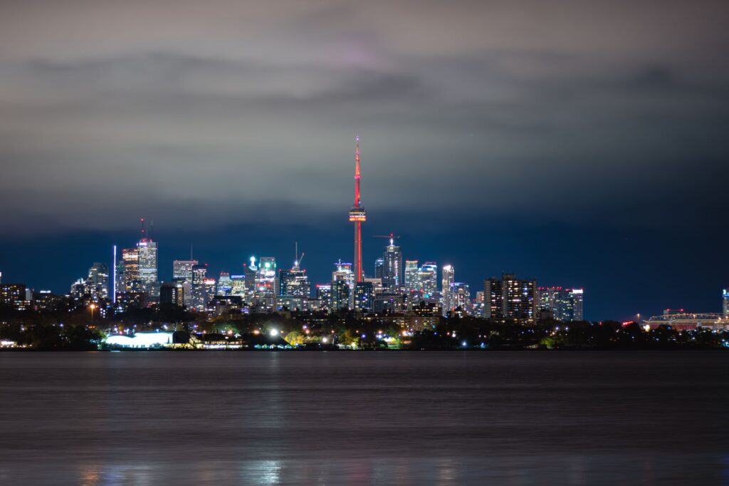 Breathtaking night view of Toronto cityscape with the iconic CN Tower glowing amidst the skyscrapers.