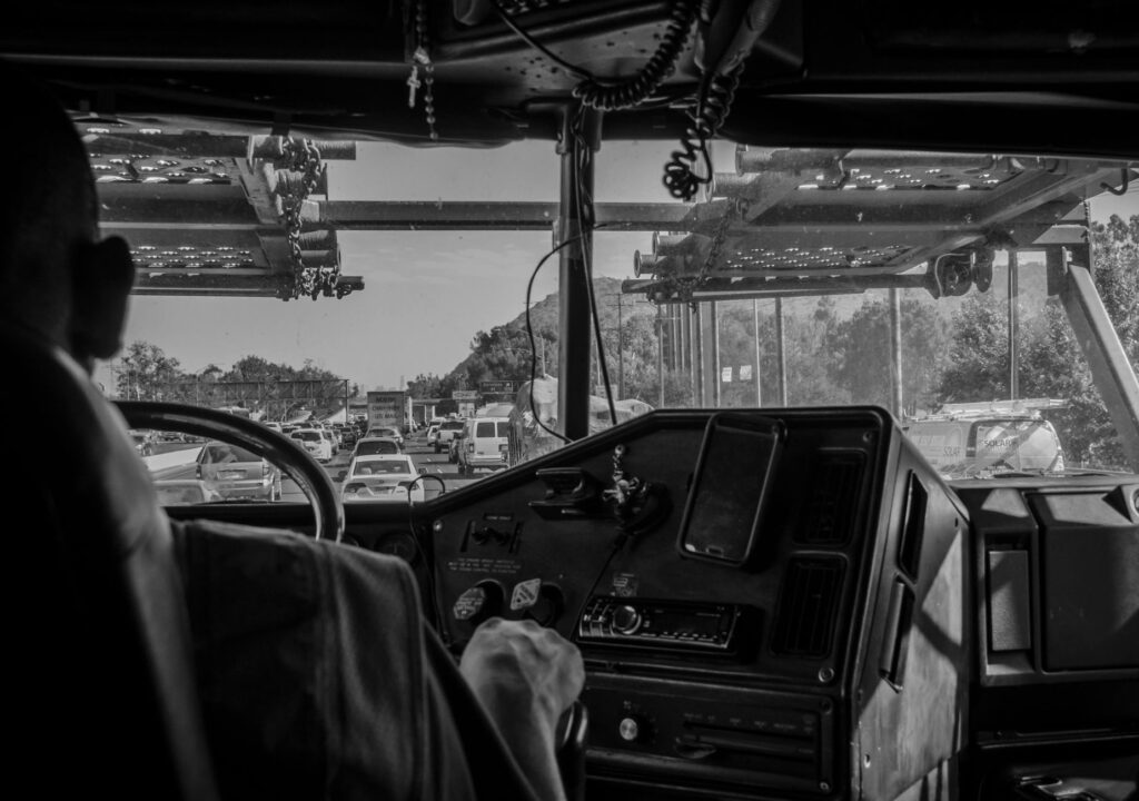 A monochrome view from inside a truck cab, showcasing traffic ahead on a busy highway.