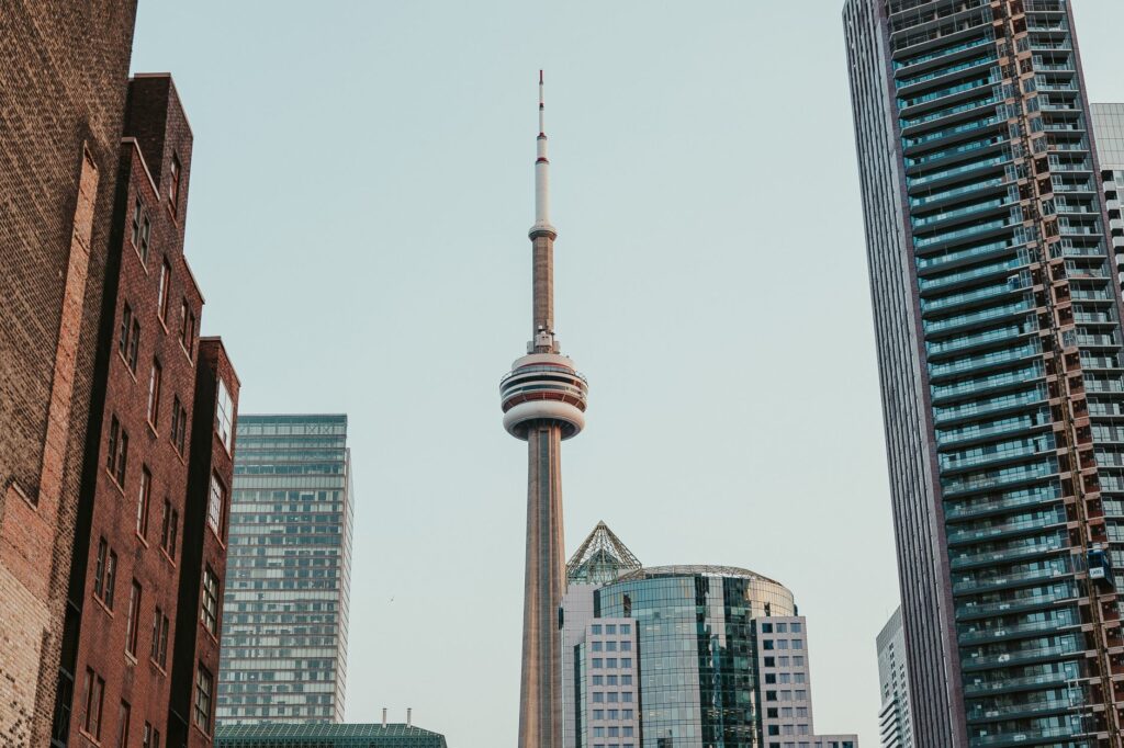 Urban skyline view of Toronto, highlighting the iconic CN Tower amid tall buildings.